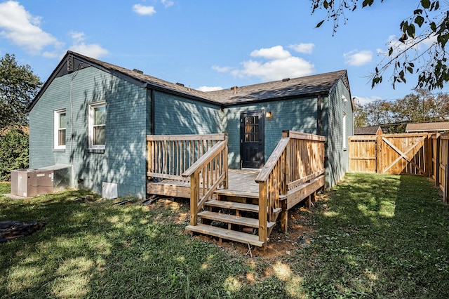 back of property featuring a yard, a wooden deck, and central AC