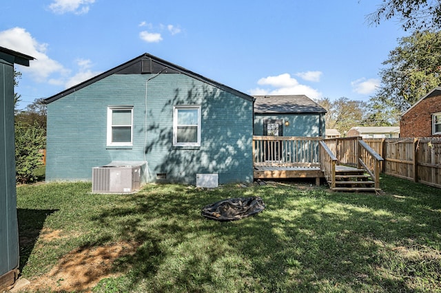 rear view of house featuring a lawn, a wooden deck, and central air condition unit