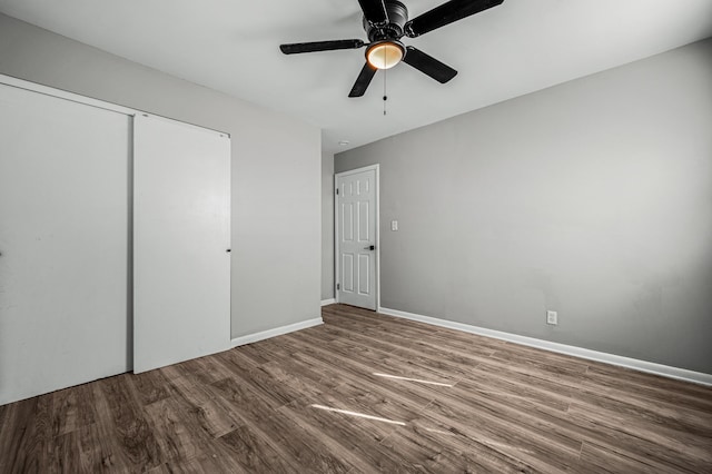 unfurnished bedroom featuring ceiling fan, a closet, and hardwood / wood-style flooring