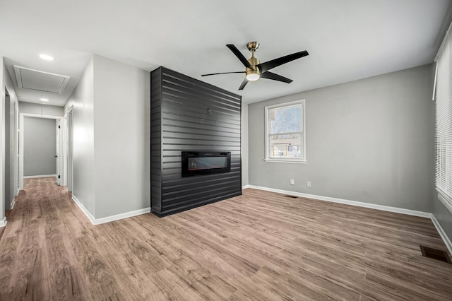 unfurnished living room with hardwood / wood-style floors, ceiling fan, and a fireplace