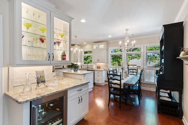 kitchen with a wealth of natural light, white cabinetry, and beverage cooler