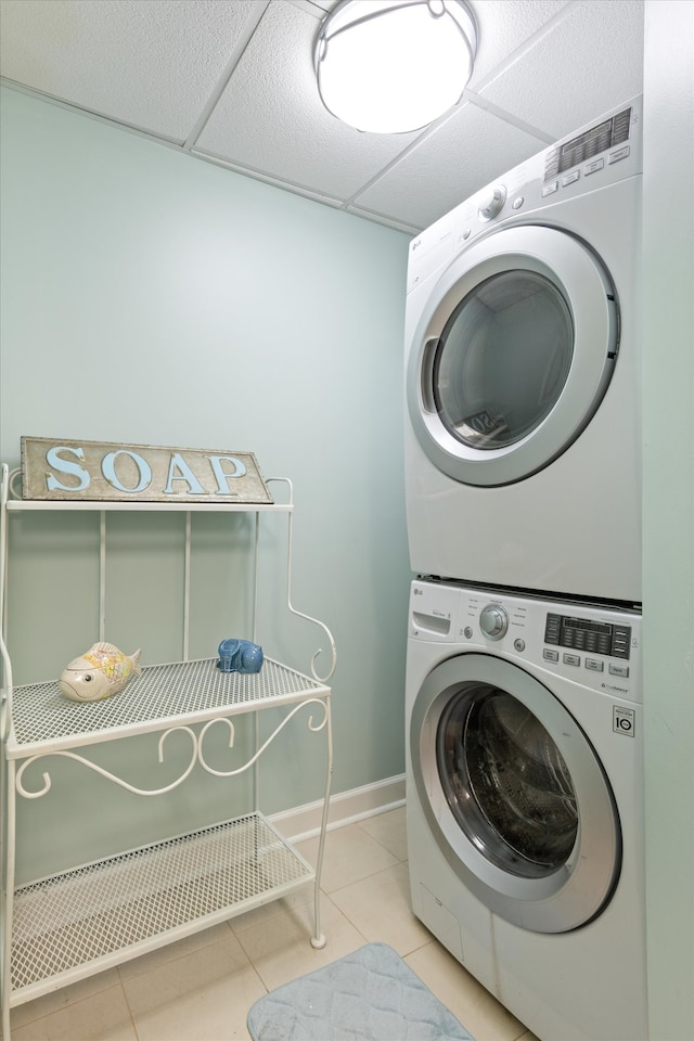 washroom with light tile patterned floors and stacked washing maching and dryer