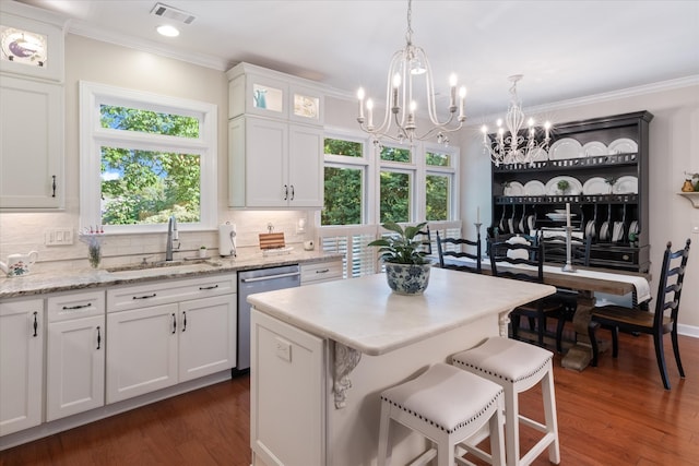 kitchen featuring a kitchen island, stainless steel dishwasher, dark hardwood / wood-style floors, decorative light fixtures, and white cabinets