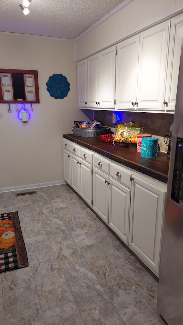 kitchen featuring white cabinets, stainless steel refrigerator with ice dispenser, and a textured ceiling