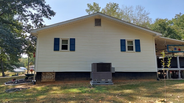 view of side of home with a lawn and central air condition unit