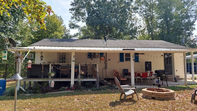 back of property featuring a patio and a fire pit