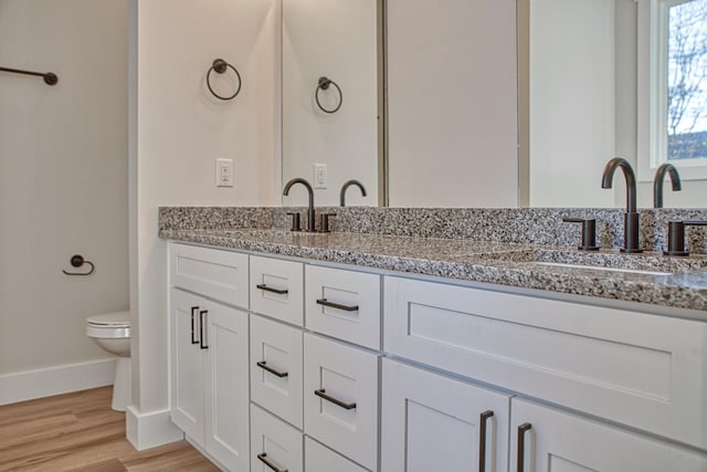 bathroom with hardwood / wood-style floors, vanity, and toilet