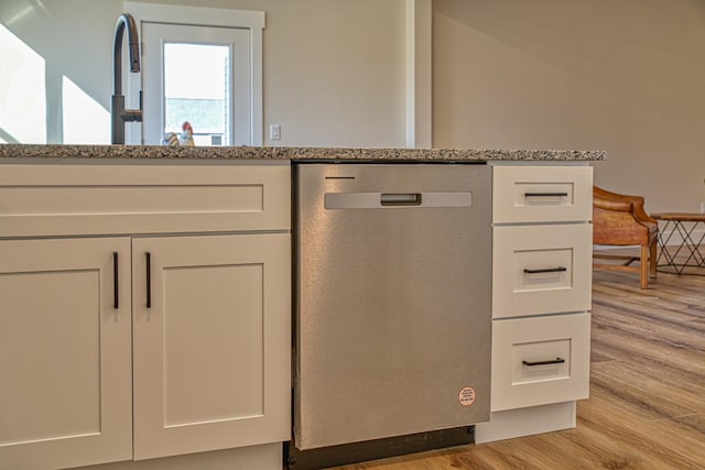 room details featuring white cabinets, dishwasher, light hardwood / wood-style floors, and light stone counters