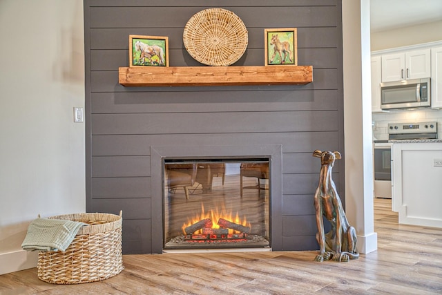 details with electric stove, decorative backsplash, and hardwood / wood-style floors