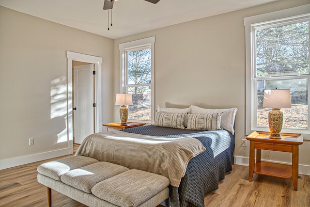 bedroom with multiple windows, ceiling fan, and light hardwood / wood-style floors