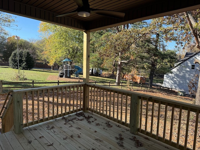 wooden terrace with ceiling fan, a playground, and a yard