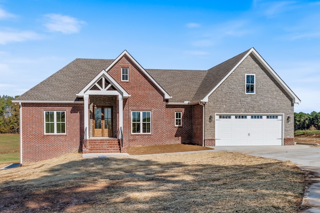 craftsman-style home featuring a front lawn, a garage, and french doors