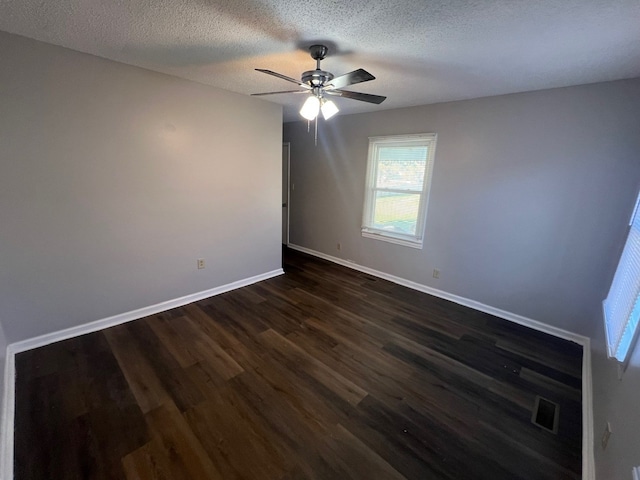 spare room with a textured ceiling, dark hardwood / wood-style flooring, and ceiling fan