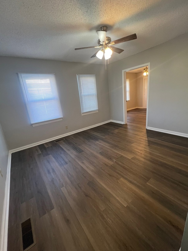 spare room featuring ceiling fan, dark hardwood / wood-style flooring, and a textured ceiling