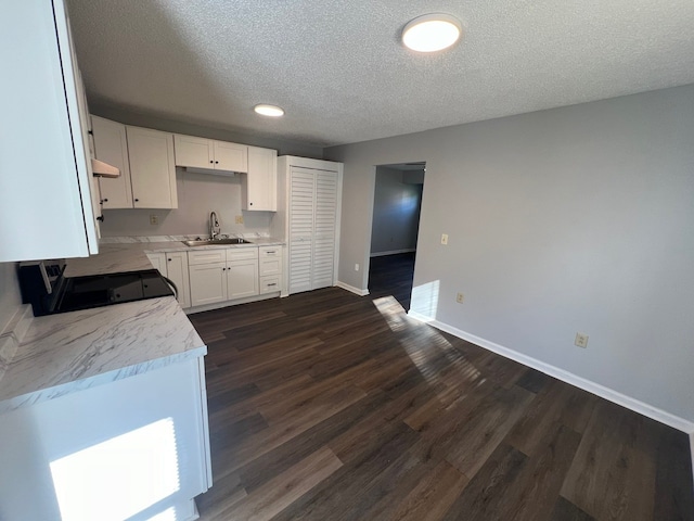 kitchen featuring black stove, sink, a textured ceiling, dark hardwood / wood-style flooring, and white cabinetry