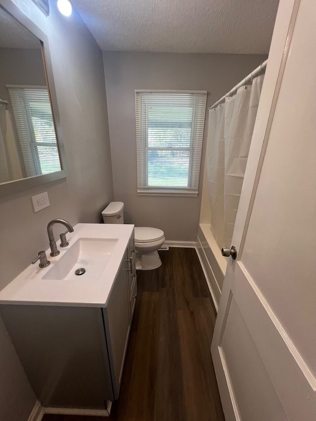 bathroom featuring vanity, a shower with curtain, hardwood / wood-style flooring, toilet, and a textured ceiling