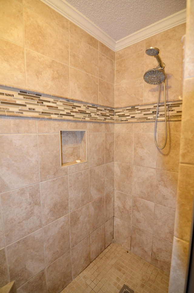 bathroom with crown molding, a textured ceiling, and tiled shower