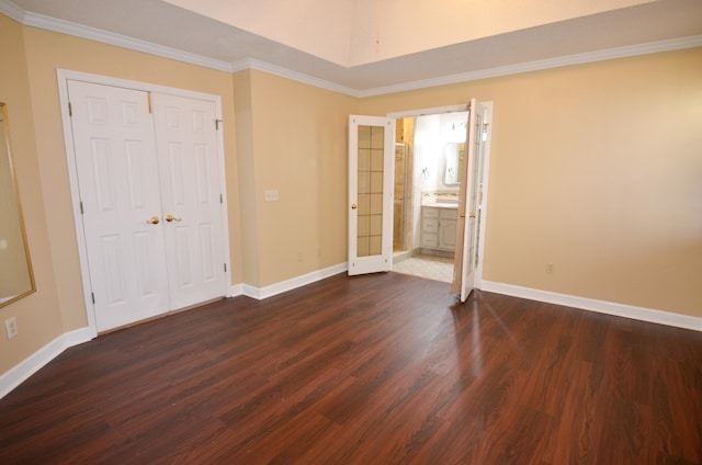 unfurnished bedroom with dark hardwood / wood-style flooring, ornamental molding, connected bathroom, and a closet