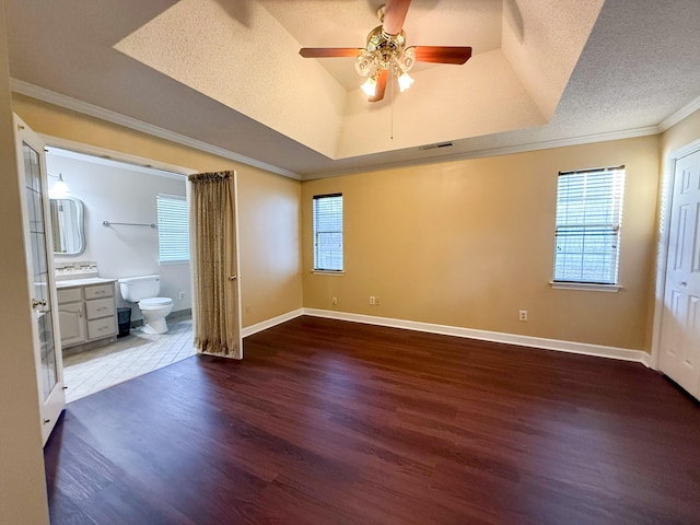 unfurnished bedroom with ceiling fan, dark hardwood / wood-style flooring, ensuite bathroom, a textured ceiling, and ornamental molding