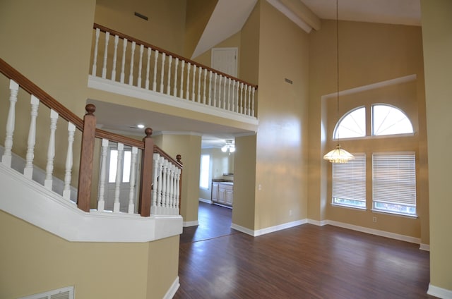 foyer entrance with a chandelier, beam ceiling, dark hardwood / wood-style flooring, and high vaulted ceiling