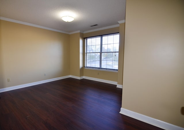 spare room with a textured ceiling, ornamental molding, and dark wood-type flooring