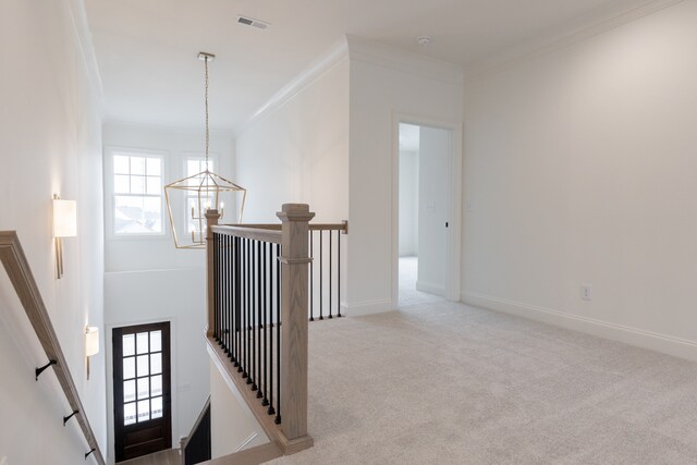 interior space featuring light carpet, a chandelier, and ornamental molding