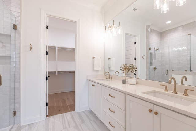 bathroom featuring crown molding, hardwood / wood-style floors, vanity, and a shower with shower door