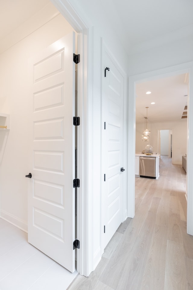 hall featuring light hardwood / wood-style floors and a notable chandelier