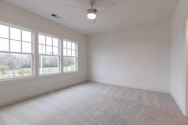 carpeted spare room featuring ceiling fan