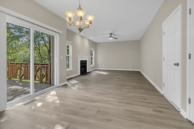 unfurnished living room with hardwood / wood-style flooring and ceiling fan with notable chandelier