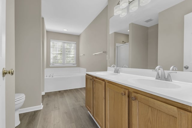 full bathroom with hardwood / wood-style floors, vanity, shower with separate bathtub, and toilet