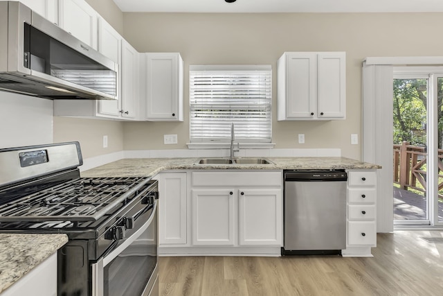 kitchen with light stone countertops, stainless steel appliances, sink, light hardwood / wood-style floors, and white cabinetry