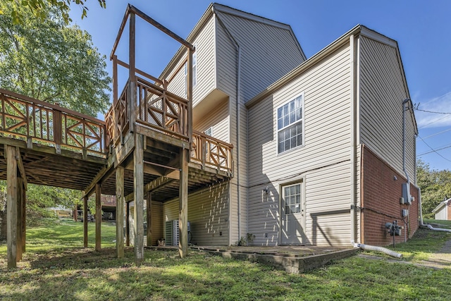 rear view of property with a wooden deck and a yard