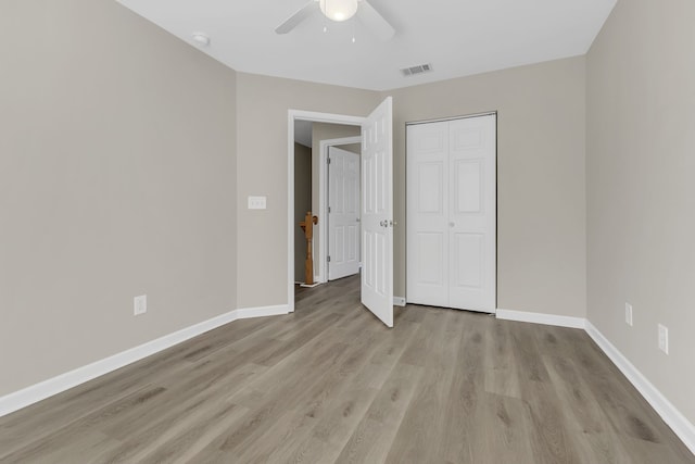 unfurnished bedroom featuring ceiling fan, a closet, and light hardwood / wood-style flooring