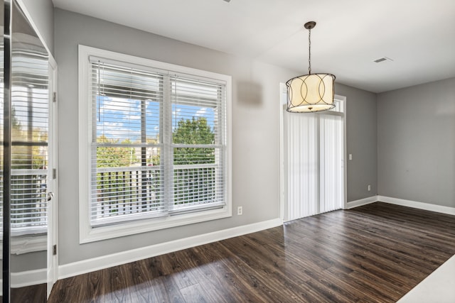 unfurnished dining area featuring dark hardwood / wood-style flooring and a wealth of natural light