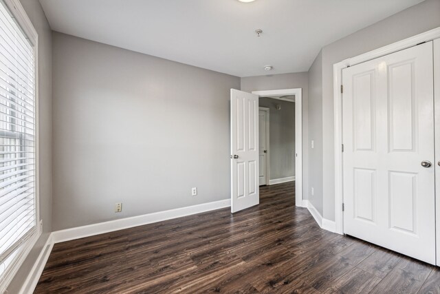 unfurnished bedroom featuring dark hardwood / wood-style flooring and a closet