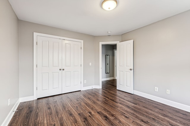 unfurnished bedroom with dark hardwood / wood-style flooring and a closet