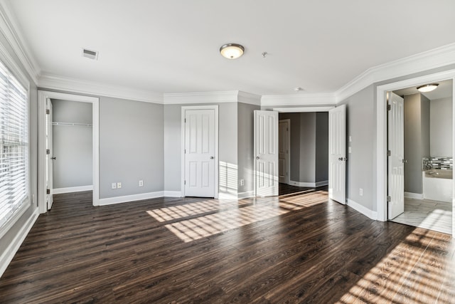 unfurnished bedroom featuring multiple windows, dark wood-type flooring, and ornamental molding