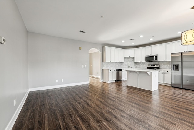 3200 Long Blvd Unit 4, Nashville, TN 37203 - kitchen with appliances with stainless steel finishes, arched walkways, open floor plan, decorative backsplash, and dark wood-style flooring
