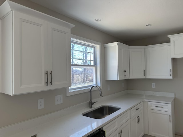 kitchen featuring white cabinetry and sink