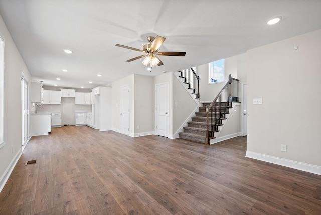 unfurnished living room with recessed lighting, wood finished floors, visible vents, baseboards, and stairs