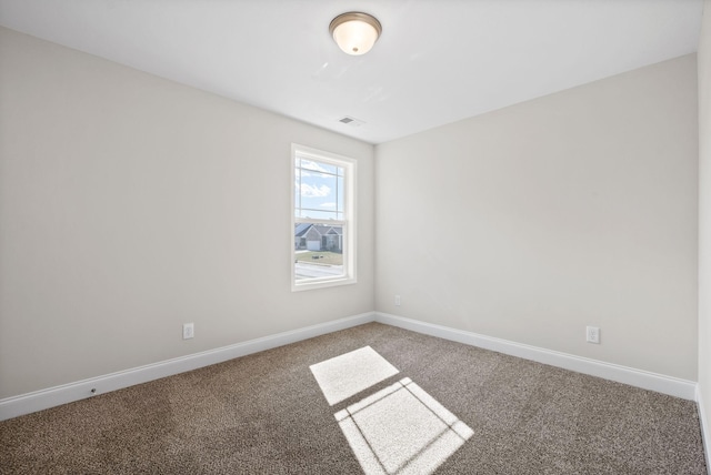 carpeted spare room featuring visible vents and baseboards