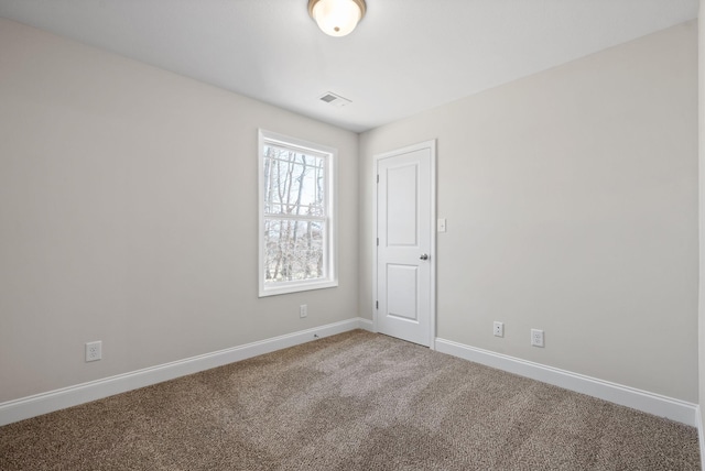 carpeted spare room with visible vents and baseboards