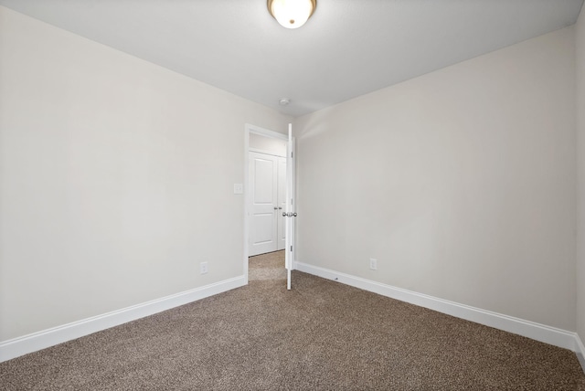 spare room featuring carpet floors and baseboards