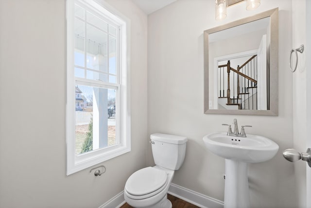 half bath featuring toilet and baseboards