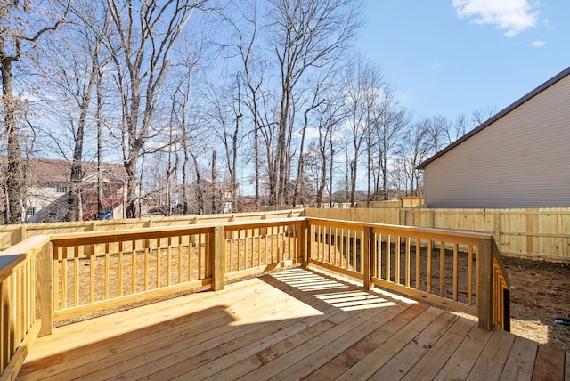 wooden terrace with a fenced backyard