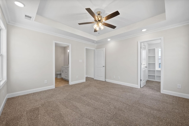 unfurnished bedroom featuring a raised ceiling, visible vents, and baseboards