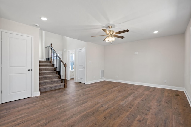 spare room featuring dark wood-style floors, recessed lighting, a ceiling fan, baseboards, and stairs