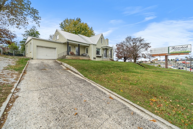 view of front of house with a porch, a front yard, and a garage