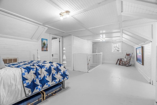 bedroom with concrete flooring and vaulted ceiling